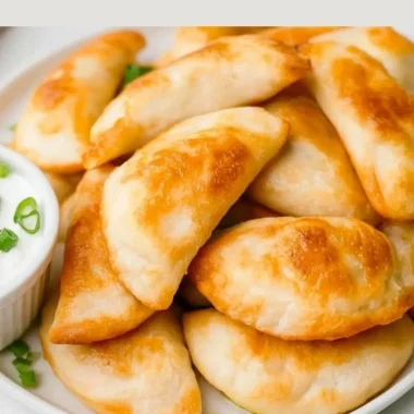 Cooked air fryer frozen pierogies on a plate garnished with herbs.