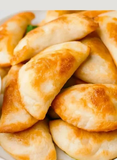 Cooked air fryer frozen pierogies on a plate garnished with herbs.