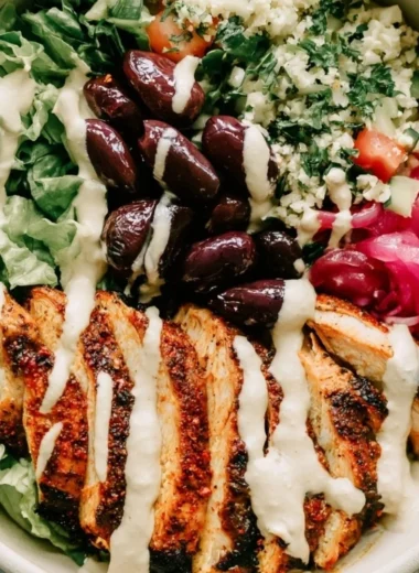 Cozy chicken shawarma meal prep bowl with colorful vegetables and sauce