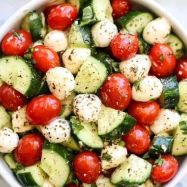 Fresh Cucumber Caprese salad with mozzarella and basil on a plate.
