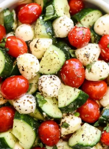 Fresh Cucumber Caprese salad with mozzarella and basil on a plate.