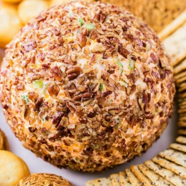 Delicious holiday cheese ball garnished with herbs and nuts