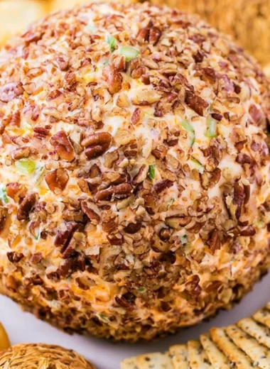 Delicious holiday cheese ball garnished with herbs and nuts